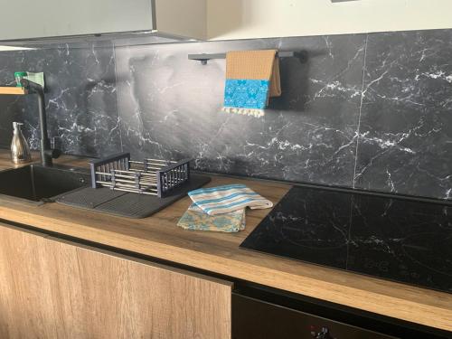 a kitchen counter with a sink and a black wall at Casa del sole in Nova Siri Marina