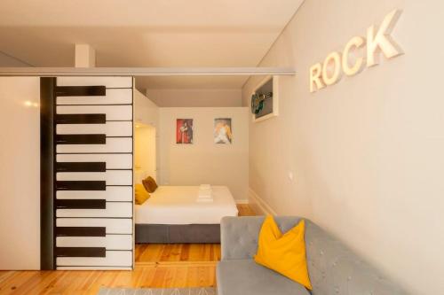 a small bedroom with a bed and a couch at Almada Music in Porto