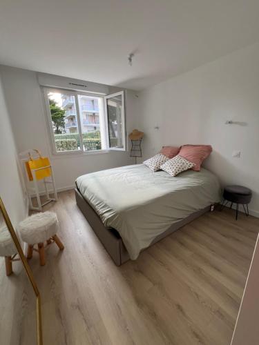 une chambre avec un grand lit et une fenêtre dans l'établissement Calme et mer, à Pornichet