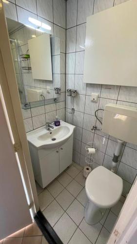 a bathroom with a white toilet and a sink at Klassiek appartement 300meter van duinen en strand in Vlissingen