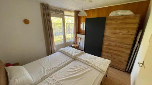 a bedroom with a bed and a wooden door at Klassiek appartement 300meter van duinen en strand in Vlissingen