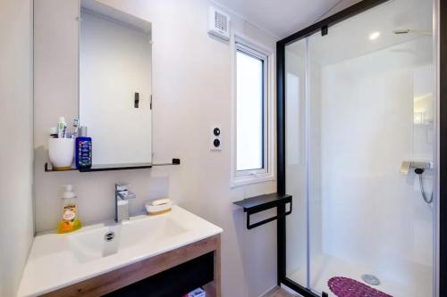 une salle de bain blanche avec un lavabo et une douche dans l'établissement Bungalow charmant à Saint-Raphaël, à Saint-Raphaël