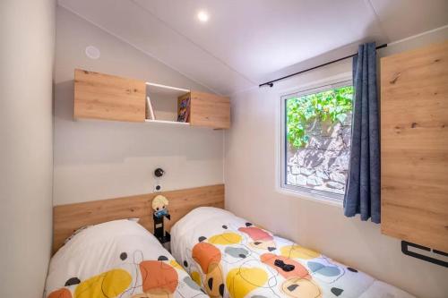 une petite chambre avec deux lits et une fenêtre dans l'établissement Bungalow charmant à Saint-Raphaël, à Saint-Raphaël