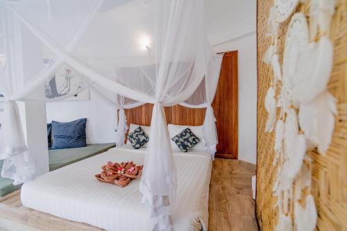 a bedroom with two beds with a canopy at The Onion Collective in Ubud