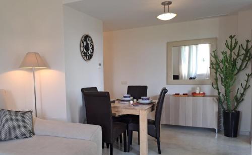 a living room with a table and chairs and a couch at Noctua valle romano golf 015 in Estepona