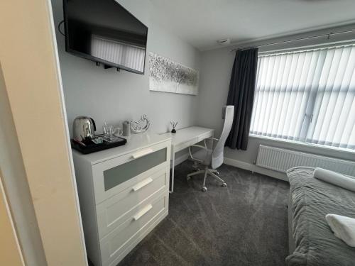 a bedroom with a desk and a bed and a desk and a computer at LYMM LIVING in Warrington