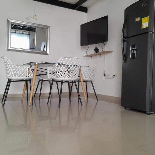 a dining room with a table and a refrigerator at CIC Apartamento amoblado Mirador del Sinú in Montería