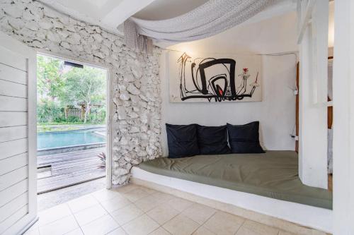 a bedroom with a bed and a window and a pool at The Onion Collective in Ubud