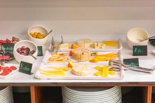 a table with three trays of cheese and other foods at Metropol Hotel in Ferizaj