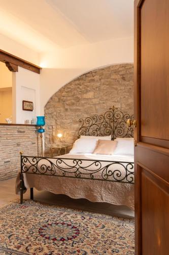 a bedroom with a bed with a stone wall at Tramonto sul Lago in Passignano sul Trasimeno
