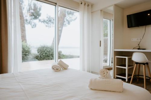 a bedroom with a large white bed with towels on it at Maison Vue Mer - Plage à Pied in La Trinité-sur-Mer