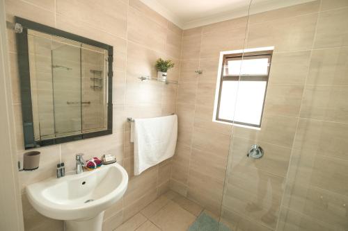 a bathroom with a sink and a shower at Hermanus Reefs in Hermanus