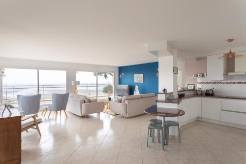 une cuisine et un salon avec un canapé et une table dans l'établissement Glaz-Zen - Spacieux appt face à la mer, à Erquy