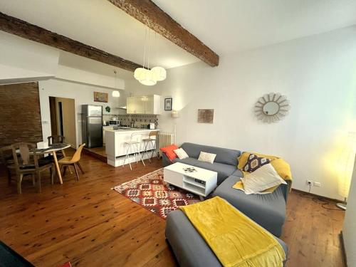 un salon avec un canapé et une cuisine dans l'établissement Appartement Capitole Daurade, à Toulouse