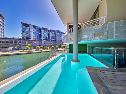 a swimming pool in the middle of a building at Birds-eye canal view - Walk to CTICC and V&A Waterfront! in Cape Town