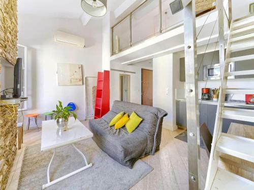 un salon avec un canapé gris et des coussins jaunes dans l'établissement Cosy duplex, hyper centre, wifi,air conditionner, à Nice