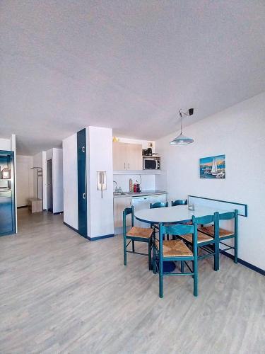 une pièce avec une table et des chaises et une cuisine dans l'établissement V-Marin 03-Vieux Boucau Appartement 6 personnes dans résidence avec piscine au bord du lac marin, à Vieux-Boucau-les-Bains
