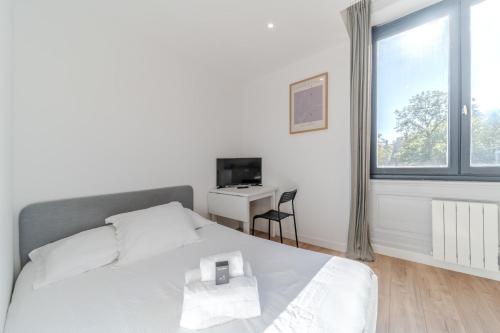 Un dormitorio con una cama y un escritorio y una ventana. en Maison Fontanières Studio Laurent 2 persons, en La Mulatière