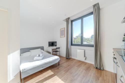 une chambre blanche avec un lit et une fenêtre dans l'établissement Maison Fontanières Studio Laurent 2 persons, à La Mulatière