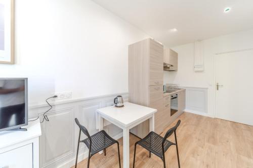 - une cuisine blanche avec une table et deux chaises dans l'établissement Maison Fontanières Le Mourguet Cosy - 2 People, à La Mulatière