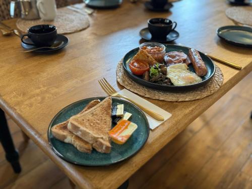 two plates of breakfast food on a wooden table at The Olivers Guest House in Hereford