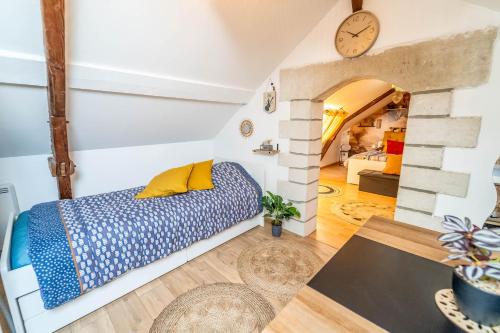 Cette chambre comprend un lit et une horloge murale. dans l'établissement Double Appartement 10min d'Honfleur, à Honfleur