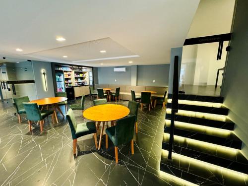 a restaurant with tables and chairs and stairs at Flat Cabo Branco a 50m do mar in João Pessoa