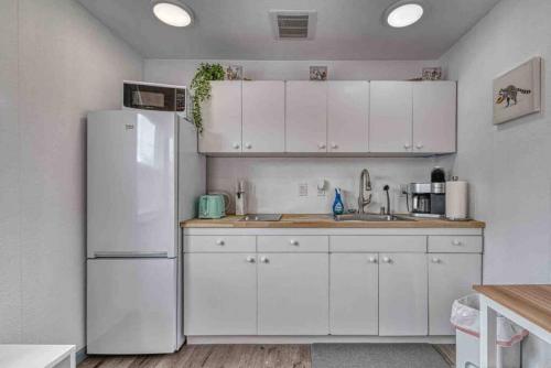 a kitchen with white cabinets and a white refrigerator at Bo360 Tiny House Unique Country Retreat with Hot Tub in Puyallup