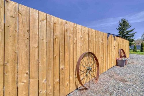 a wooden fence with a large wooden wheel at Bo360 Tiny House Unique Country Retreat with Hot Tub in Puyallup