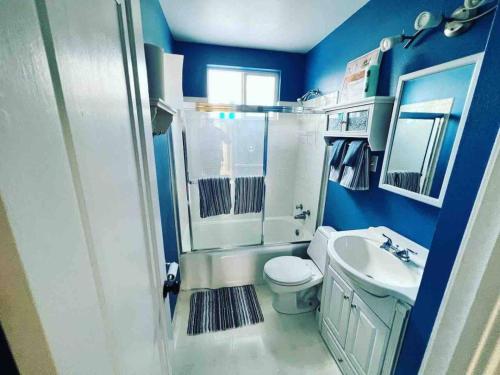 une salle de bain bleue avec des toilettes et un lavabo dans l'établissement Bo's charming two bedroom with shared HOT TUB, à Billings