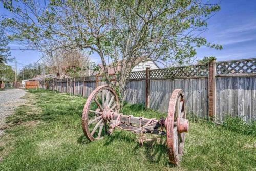 an old wagon sitting in the grass next to a fence at Bo360 Tiny House Unique Country Retreat with Hot Tub in Puyallup