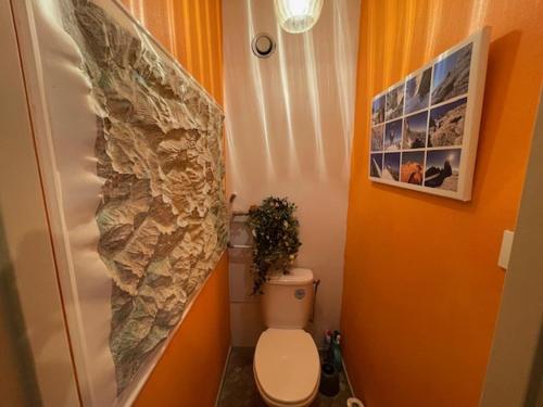 La salle de bains est pourvue de toilettes et d'un mur en pierre. dans l'établissement Appartement accueillant au pied des pistes avec balcon et cuisine équipée - FR-1-516-21, à Les Deux Alpes
