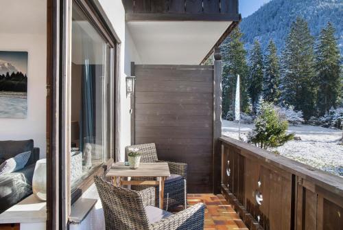 a balcony with chairs and a table with a view at Almzeit in Farchant