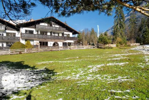 a large building with a grass field in front of it at Almzeit in Farchant