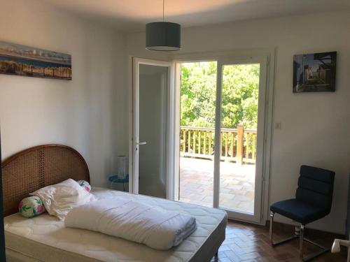 une chambre avec un lit et une porte coulissante en verre dans l'établissement Villa CapFerret sous les pins,bassin et océan à pied, à Lège-Cap-Ferret