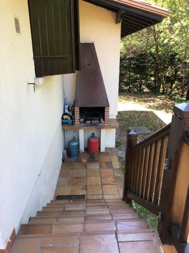 d'une terrasse avec un barbecue sur le côté d'une maison. dans l'établissement Villa CapFerret sous les pins,bassin et océan à pied, à Lège-Cap-Ferret
