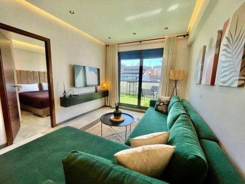 丹吉尔Natural Harmony Suite - 2 BR Marina Bay Beach View的带绿色沙发的客厅和卧室