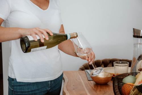 a woman pouring a glass of wine at Boutique Hotel GreenLeaf in Sinzing