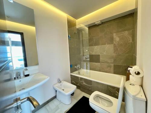 丹吉尔Natural Harmony Suite - 2 BR Marina Bay Beach View的带水槽、马桶和浴缸的浴室