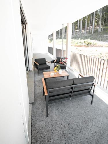 a porch with a couch and a table on a balcony at Boutique Hotel GreenLeaf in Sinzing
