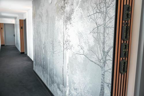 a wall with a painting of trees on it at Boutique Hotel GreenLeaf in Sinzing