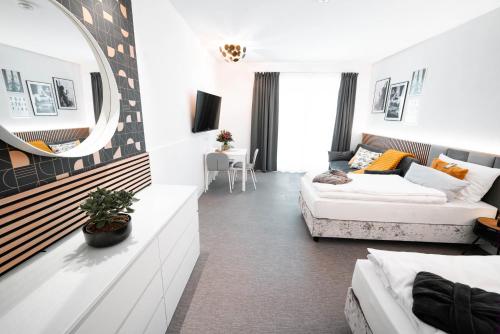 a living room with a couch and a mirror at Boutique Hotel GreenLeaf in Sinzing