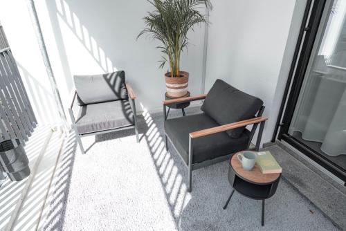 a balcony with two chairs and a table and a plant at Boutique Hotel GreenLeaf in Sinzing