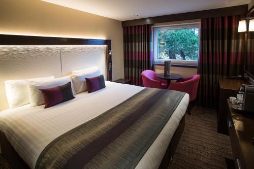 um quarto de hotel com uma cama grande e uma janela em Mondo Hotel em Coatbridge