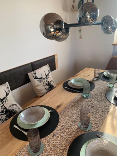 a wooden table with plates on top of it at Ferienwohnung Geyersberg 704 in Hauzenberg