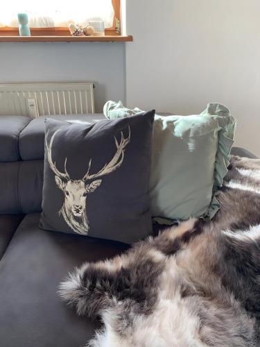 a cushion with a deer head on a couch at Ferienwohnung Geyersberg 704 in Hauzenberg