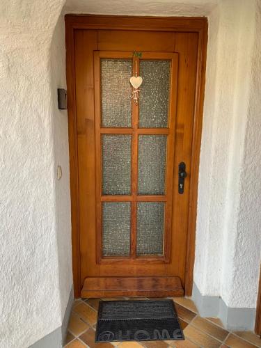 a wooden door with a window and a mat in front at Ferienwohnung Geyersberg 704 in Hauzenberg