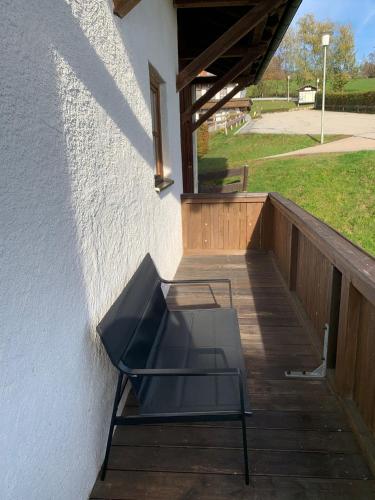 a chair sitting on a porch next to a building at Ferienwohnung Geyersberg 704 in Hauzenberg