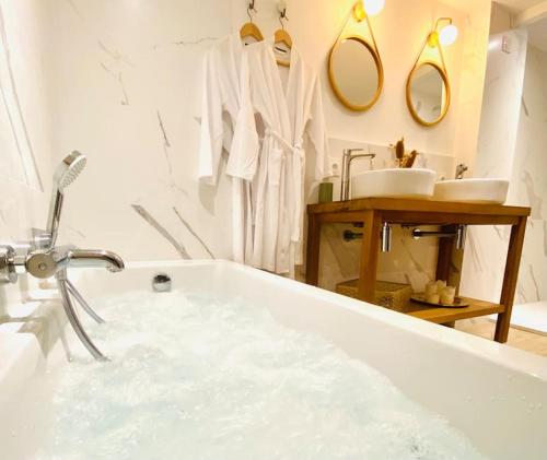 une salle de bain blanche avec une baignoire et un lavabo dans l'établissement La Rochelle Royale - Ville, à La Rochelle