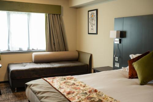 a hotel room with a bed and a couch at Cat & Lion Country Pub and Hotel in Warrington